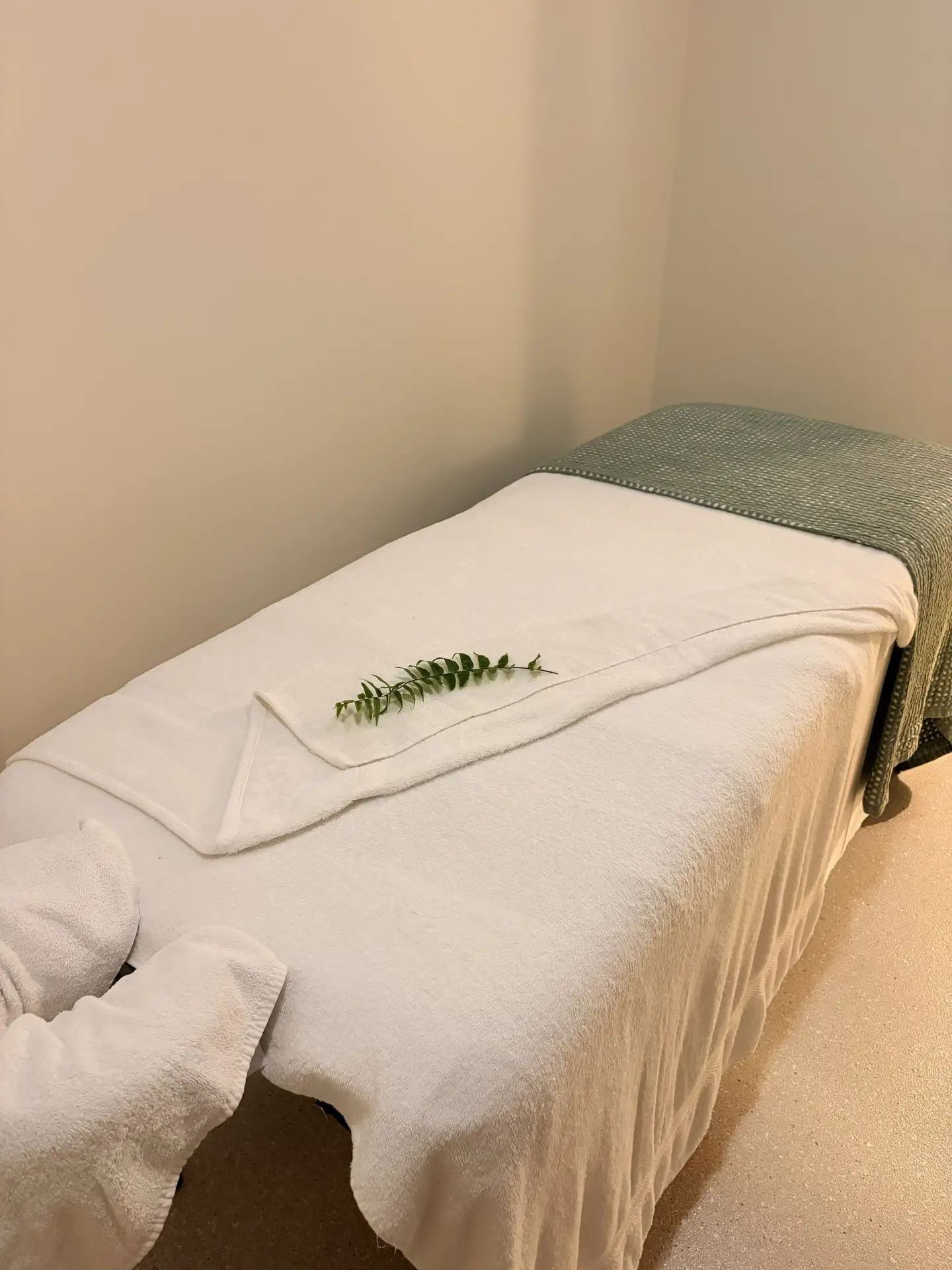 Massage table in room with white towels.